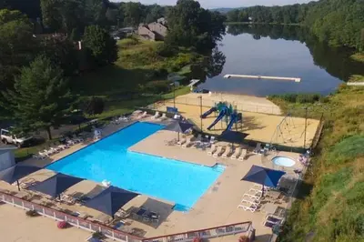 an overhead view of a large swimming pool next to a lake at Regent Hilltop Cabin in Sandyville