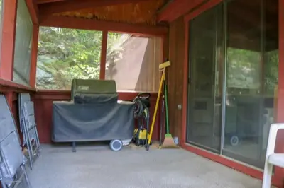 a screened in porch with a mop and a window at Regent Hilltop Cabin in Sandyville