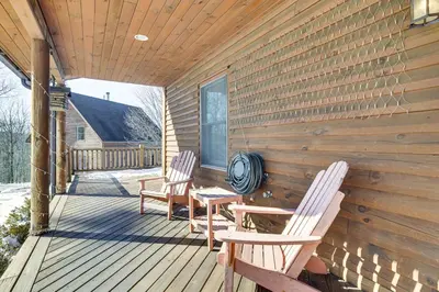 two chairs and a table on the porch of a cabin at Quiet Snow Estate Retreat in the Poconos in Nay Aug