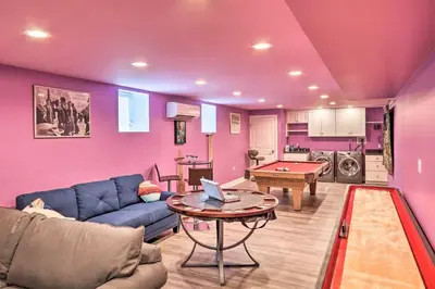 a living room with a blue couch and a table at 16 Mi to Camelback Resort Getaway with Game Room in Saylorsburg