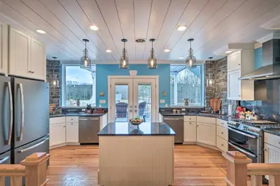 a large kitchen with white cabinets and blue walls at 16 Mi to Camelback Resort Getaway with Game Room in Saylorsburg