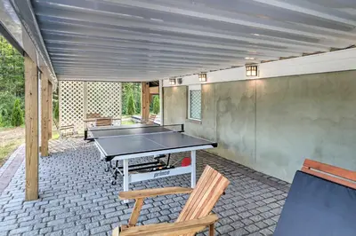 a patio with a ping pong table and two chairs at 16 Mi to Camelback Resort Getaway with Game Room in Saylorsburg