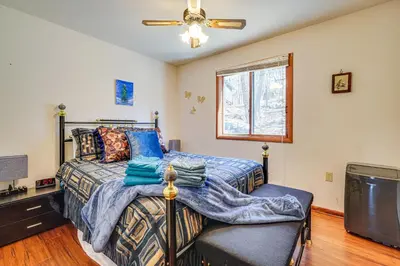 a bedroom with a bed and a ceiling fan at Fire Pit and Gas Grill Charming Poconos Abode! in Bushkill