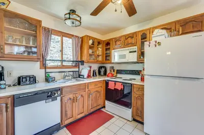 a kitchen with wooden cabinets and a white refrigerator at Fire Pit and Gas Grill Charming Poconos Abode! in Bushkill