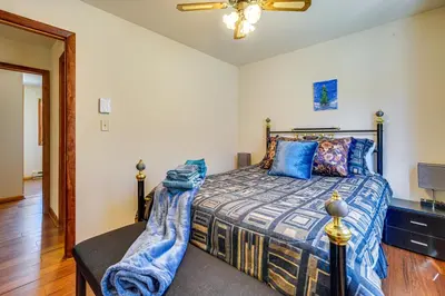 a bedroom with a bed with a blue comforter at Fire Pit and Gas Grill Charming Poconos Abode! in Bushkill