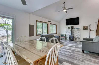 a dining room and living room with a wooden table and chairs at Screened Porch and Deck Pet-Friendly Poconos Escape in Lackawaxen