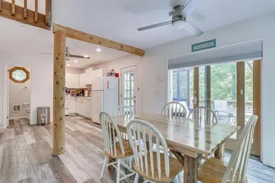 a dining room and kitchen with a wooden table and chairs at Screened Porch and Deck Pet-Friendly Poconos Escape in Lackawaxen