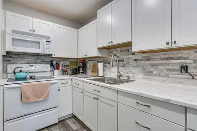 a kitchen with white cabinets and a sink at Screened Porch and Deck Pet-Friendly Poconos Escape in Lackawaxen