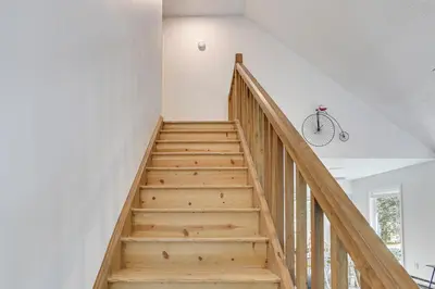 a staircase in a house with a bike hanging on the wall at Screened Porch and Deck Pet-Friendly Poconos Escape in Lackawaxen