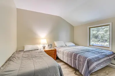 two beds in a room with a window at Screened Porch and Deck Pet-Friendly Poconos Escape in Lackawaxen
