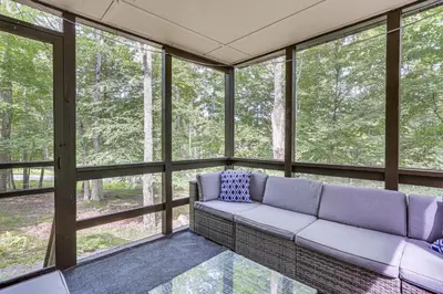 a living room with a couch in front of windows at Screened Porch and Deck Pet-Friendly Poconos Escape in Lackawaxen