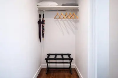 a walk in closet with a black bench and umbrellas at Artsy Hidden Gem --- FREE PARKING in Philadelphia