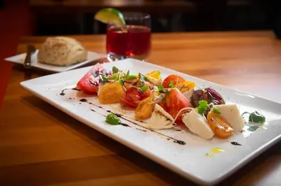 a white plate of food on a wooden table at Holiday Inn Lancaster by IHG in Lancaster