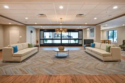 a lobby with two couches and a chandelier at Holiday Inn Lancaster by IHG in Lancaster
