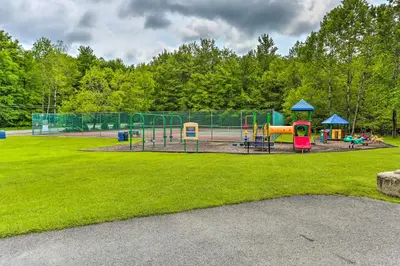 a park with a playground in the grass at Excellent Lakeview Getaway with Watercrafts Included in Pocono Lake
