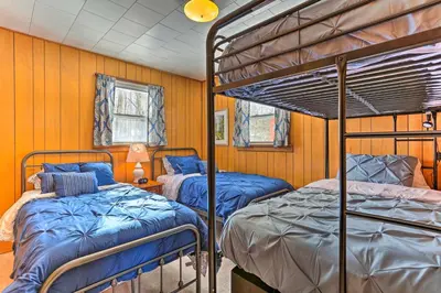 two bunk beds in a room with wooden walls at Excellent Lakeview Getaway with Watercrafts Included in Pocono Lake