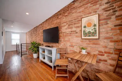 a brick wall with a television and a table at Artsy Hidden Gem - FREE PARKING in Philadelphia