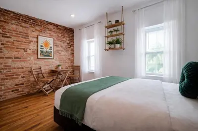 a bedroom with a bed and a brick wall at Artsy Hidden Gem - FREE PARKING in Philadelphia