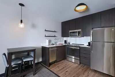 a kitchen with stainless steel appliances and wooden cabinets at Residence Inn New Brunswick Tower Center Blvd. in East Brunswick