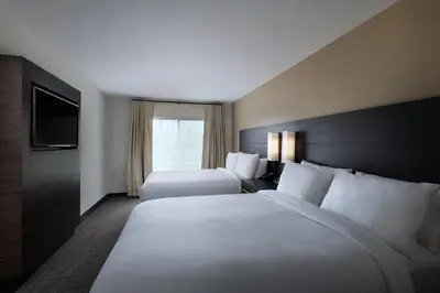 a hotel room with two beds and a television at Residence Inn New Brunswick Tower Center Blvd. in East Brunswick