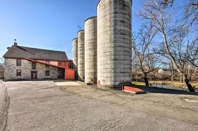 a barn with three silos in front of a building at Creek Access and Deck Runningwater Lancaster Gem in Lancaster