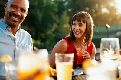 a man and a woman sitting at a table with drinks at Camelback Resort in Tannersville