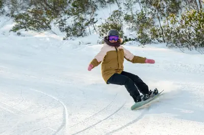 a person riding a snowboard down a snow covered slope at Camelback Resort in Tannersville