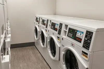 a row of washing machines in a laundry room at Residence Inn by Marriott Wilkes-Barre Arena in Wilkes-Barre