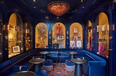 a restaurant with blue seating and a chandelier at CIVILIAN Hotel in New York