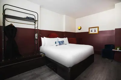 a large white bed in a room with red walls at CIVILIAN Hotel in New York