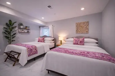 a bedroom with two beds with white sheets and pink pillows at Artsy Hidden Gem ll -Free Parking -- in Philadelphia