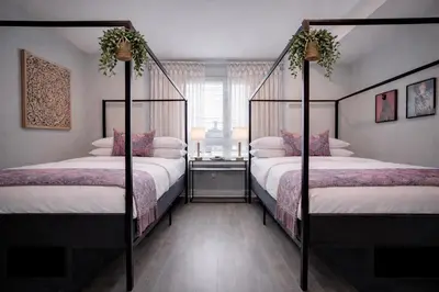 a bedroom with two four poster beds and a window at Artsy Hidden Gem ll -Free Parking -- in Philadelphia