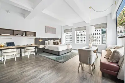 a living room with a bed and a desk at 17John in New York