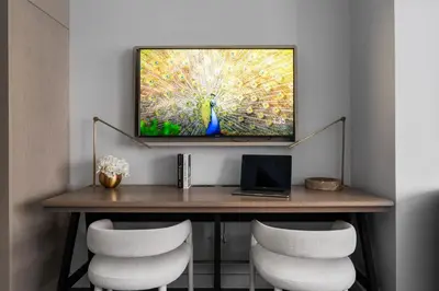 a room with a table with a television on a wall at 17John in New York