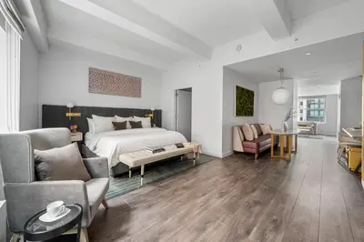 a bedroom with a bed and a living room at 17John in New York