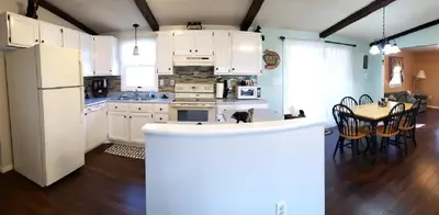 a kitchen with a white refrigerator and a table with chairs at Black Bear Lodge @ Middle Creek in Stevens