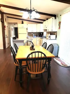 a dining room table with chairs and a kitchen at Black Bear Lodge @ Middle Creek in Stevens
