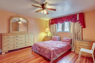 a bedroom with a bed and a dresser and a ceiling fan at 8 Mi to Liberty Bell! Spacious and Charming Home in Upper Darby