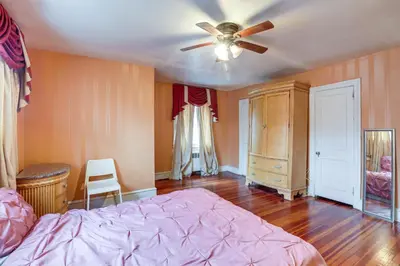 a bedroom with a bed and a ceiling fan at 8 Mi to Liberty Bell! Spacious and Charming Home in Upper Darby
