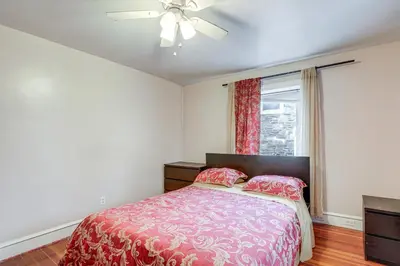 a bedroom with a bed and a ceiling fan at 8 Mi to Liberty Bell! Spacious and Charming Home in Upper Darby