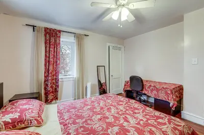 a bedroom with a bed and a ceiling fan at 8 Mi to Liberty Bell! Spacious and Charming Home in Upper Darby