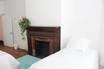 a living room with a fireplace and a bed at Legacy - Spring Garden University City in Philadelphia