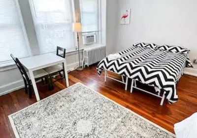 a bedroom with a bed and a table and a desk at Legacy - Spring Garden University City in Philadelphia