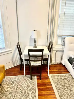 a dining room table with chairs and a lamp on it at Legacy - Spring Garden University City in Philadelphia