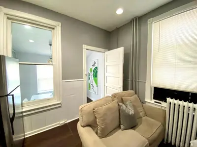 a living room with a chair and a window at Legacy - Spring Garden University City in Philadelphia