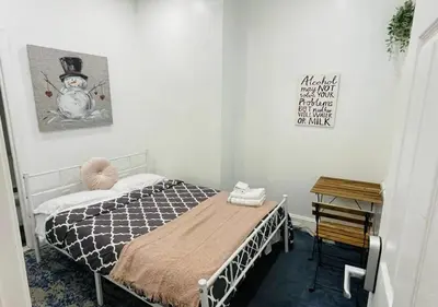 a bedroom with a bed with a snowman picture on the wall at Oui on Ludlow - Entire House and Private Rooms in University City in Philadelphia