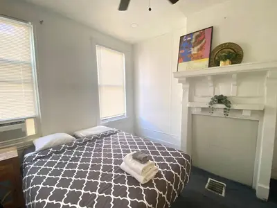 a bedroom with a bed and a fireplace at Oui on Ludlow - Entire House and Private Rooms in University City in Philadelphia