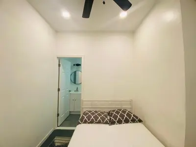 a small bedroom with a bed and a mirror at Oui on Ludlow - Entire House and Private Rooms in University City in Philadelphia