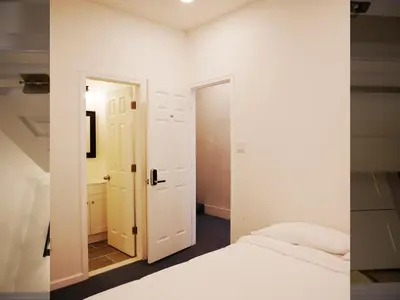 a white bedroom with a bed and a mirror at Oui on Ludlow - Entire House and Private Rooms in University City in Philadelphia