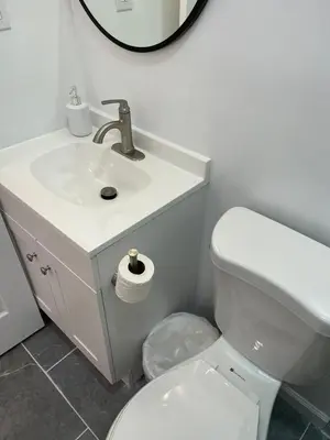 a bathroom with a sink and a toilet and a mirror at Oui on Ludlow - Entire House and Private Rooms in University City in Philadelphia